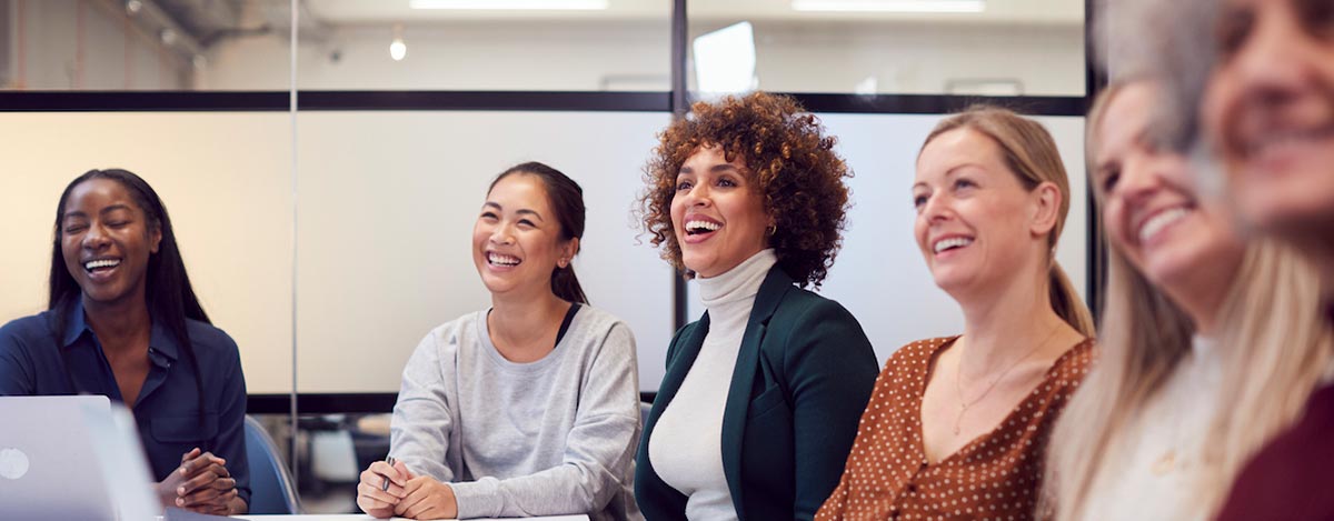 group of women marketers in a meeting, happy and smiling