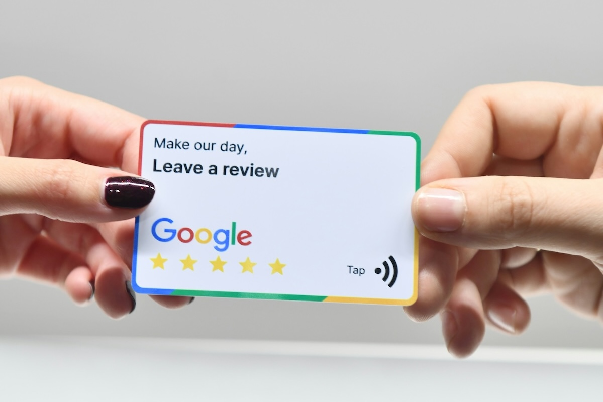 two hands holding a card encouraging customers to leave a google review